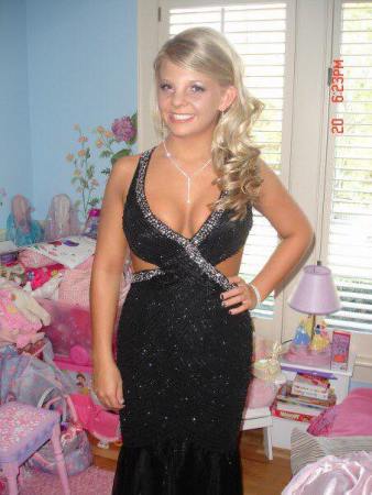 Fair skinned blonde high school student in a black and silver dress that has side cutouts and a deep neckline. that shows her cleavage